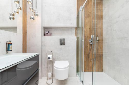 a bathroom with a shower and a toilet and a sink at Gold Flamingo Apartament by Renters in Międzyzdroje