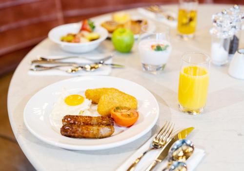 a table with a breakfast plate of eggs sausage and tomatoes at Novotel Leicester in Leicester