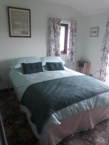 a large bed in a bedroom with a window at High Greenside in Kirkby Stephen