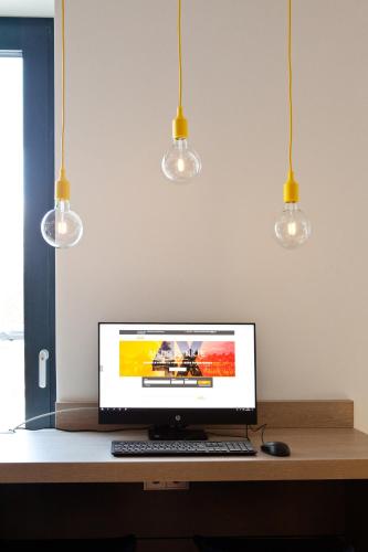 a computer monitor sitting on a desk with three lights at Holiday Inn Express - Trier by IHG in Trier