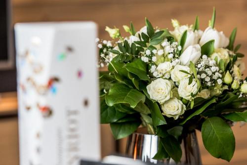 a vase filled with white flowers on a table at Manali Lodge by Alpine Resorts in Courchevel