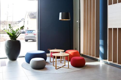 a table and chairs in a room with a window at Holiday Inn Express - Trier by IHG in Trier