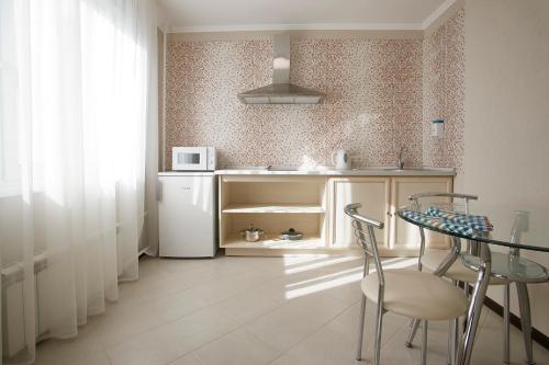 a small kitchen with a table and a refrigerator at Vladykino Apart-Hotel in Moscow