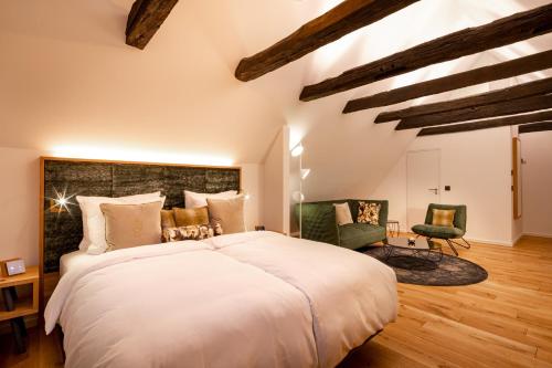 a bedroom with a large bed and two chairs at Hotel Brunnenhaus Schloss Landau in Bad Arolsen