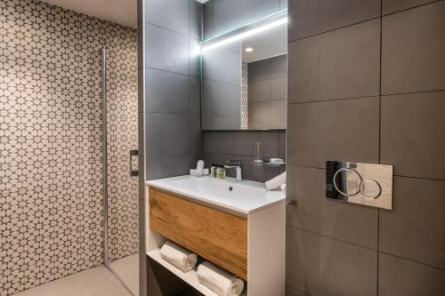 a bathroom with a sink and a shower at Manali Lodge by Alpine Resorts in Courchevel