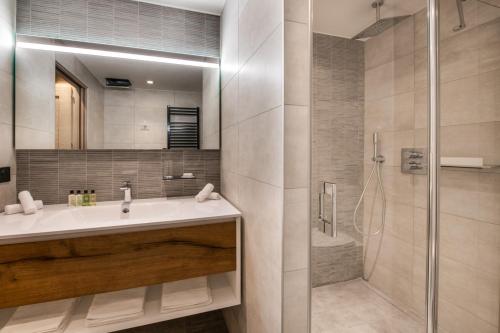 a bathroom with a sink and a shower at Manali Lodge by Alpine Resorts in Courchevel