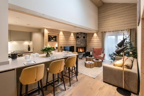 a kitchen and living room with a bar and a couch at Manali Lodge by Alpine Resorts in Courchevel