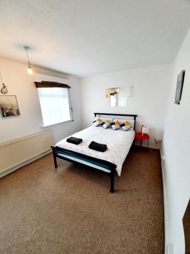 Rayleigh Town Centre 2 Bedroom Apartment في رايلي: غرفة نوم بسرير في غرفة بيضاء