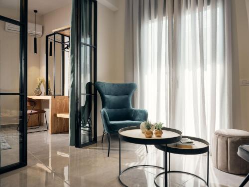 a living room with a blue chair and a table at Bella Vista Building A - 100m from Solomos Square, by ZanteWize in Zakynthos Town