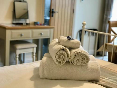 a pile of towels sitting on top of a bed at Brinsley Barn in Blagdon