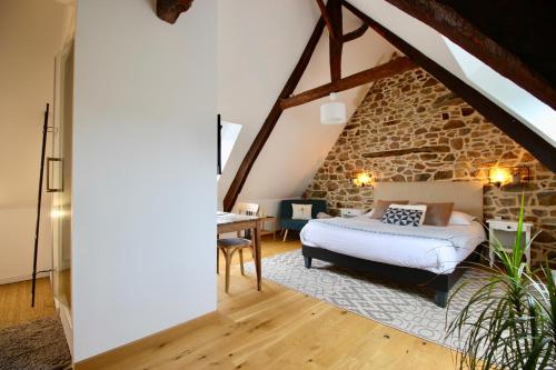 a bedroom with a bed and a desk in a attic at La Maison Kérès in Kermaria-Sulard
