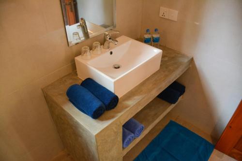 a bathroom with a sink and a counter with blue towels at Jackland Holiday Cabanas in Demanhandiya