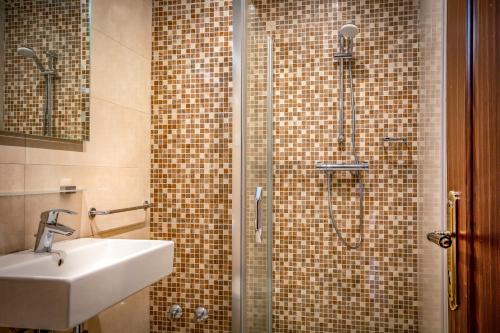 a bathroom with a shower with a sink and a shower at The Country Lodge Hotel in Freetown