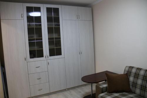 a room with white cabinets and a table and a couch at Смарт-квартира на Юності in Vinnytsya