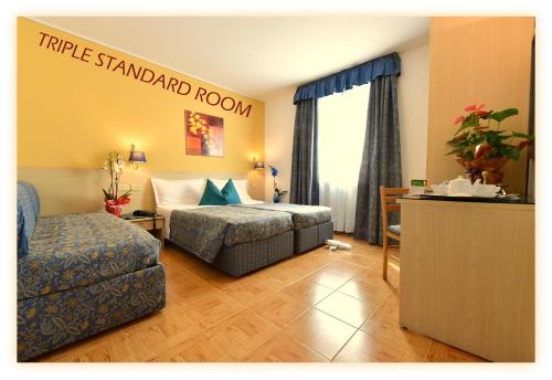a hotel room with a bed and a couch at Hotel Beau Sejour in Etroubles