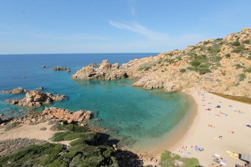 a beach with a bunch of people in the water at Costa Paradiso Resort in Costa Paradiso