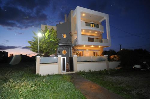 a large white house at night with a street light at Katia's House in Ampavris