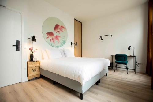 a bedroom with a large white bed and a chair at Hotel Haverkist in Den Bosch