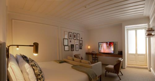a bedroom with a bed and a couch and a tv at Lisboa Pessoa Hotel in Lisbon