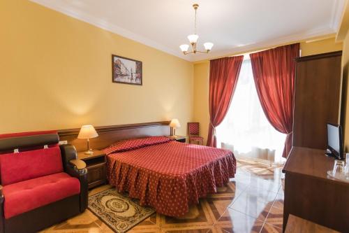 a bedroom with a red bed and a red chair at Hotel Oasis in Adler