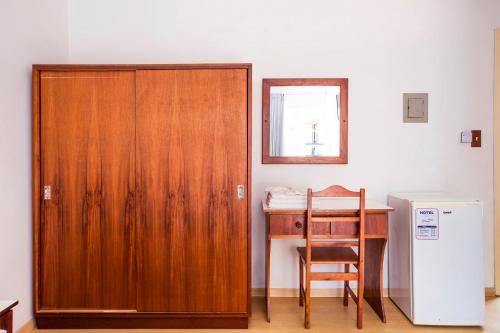 a wooden door in a room with a desk and a table at Hotel Itapema Meia Praia in Itapema