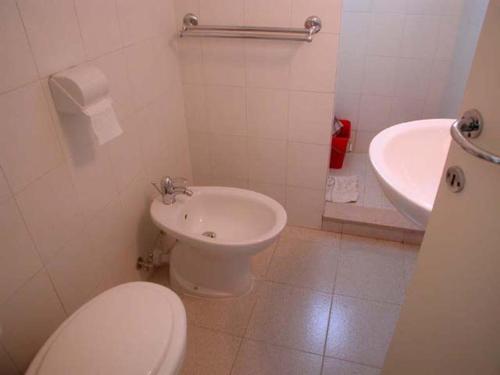 uma casa de banho branca com um WC e um lavatório em Villa Clivia em Grado