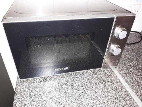 a microwave oven sitting on top of a counter at Howlands Bright 2 bed 2 bath apartment balcony with views over town in Crawley