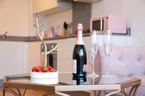 a table with a bottle of wine and two wine glasses at Sunshine Place in Enfield