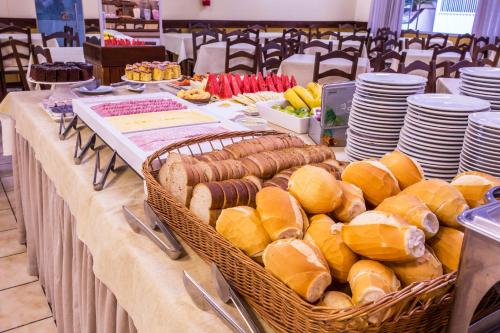 a table with baskets of bread and sandwiches on it at Hotel Itapema Meia Praia in Itapema