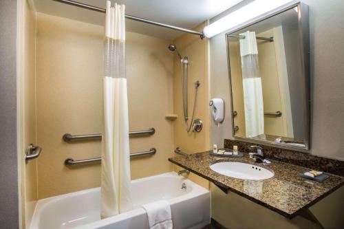 a bathroom with a bath tub and a sink at La Quinta by Wyndham Islip - MacArthur Airport in Bohemia