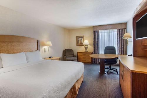 a hotel room with a bed and a desk at La Quinta by Wyndham Islip - MacArthur Airport in Bohemia