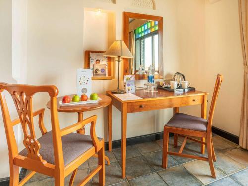 a kitchen with a table and chairs and a mirror at Novotel Bahrain Al Dana Resort in Manama