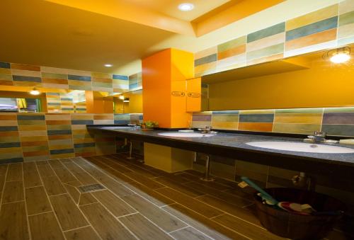 a bathroom with three sinks and a large mirror at UWA Guesthouse in Seoul