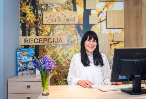 a woman sitting at a desk in front of a computer at SLATKI SNOVI II in Knin