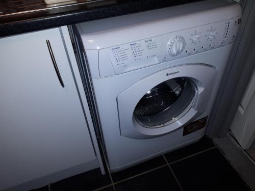 a washer and dryer in a kitchen next to a counter at The Willows in Crawley