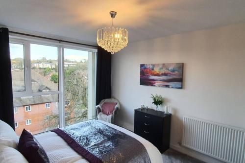 a bedroom with a chandelier and a bed and a window at The Copper Pan by Ritual Stays in Hemel Hempstead