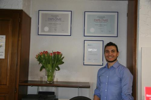 a man standing in a room with a vase of flowers at Hotel Eremitage in Arlesheim