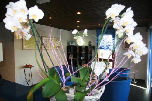 a vase filled with white flowers in a room at Hotel Eremitage in Arlesheim