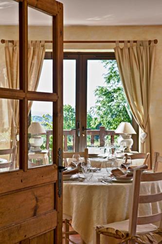 Un comedor con una mesa y una ventana. en Les Maisons de Montagne - Chez Marie, en Pailherols
