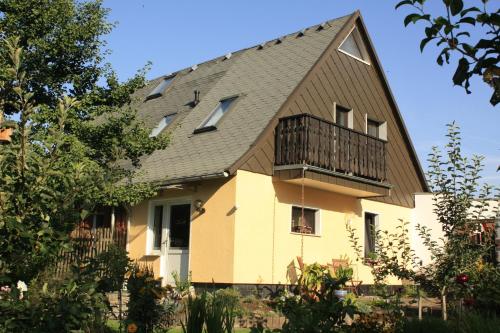 une maison avec un toit en gambrel et un balcon dans l'établissement FEWO Wittig, à Ilfeld