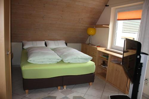 Dormitorio pequeño con cama y TV en FEWO Wittig, en Ilfeld