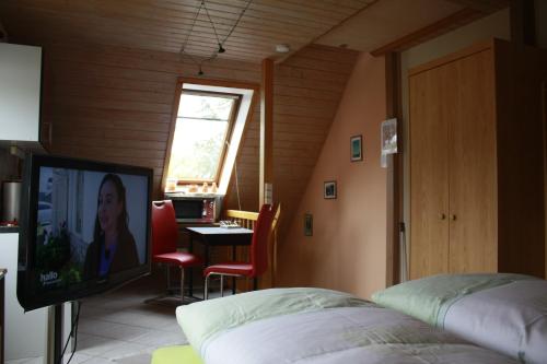 - une chambre avec un lit, une télévision et une table dans l'établissement FEWO Wittig, à Ilfeld
