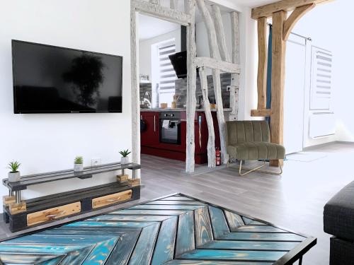 un salon avec une télévision à écran plat sur un mur dans l'établissement Eco-Appart'hôtel Rouen - BDE, à Rouen