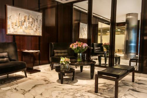 a lobby with chairs and tables with flowers on them at Awwa Suites & Spa in Buenos Aires