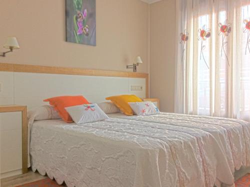 Un dormitorio con una cama con almohadas de colores. en Casa Mar de Fondo, en A Telleira