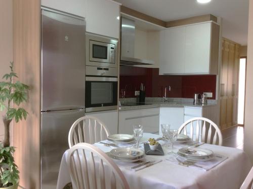 a kitchen with a table with a white table cloth and chairs at Casa Mar de Fondo in A Telleira