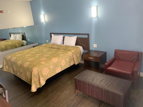 um quarto de hotel com uma cama e uma cadeira em Crescent Inn em Wilmington