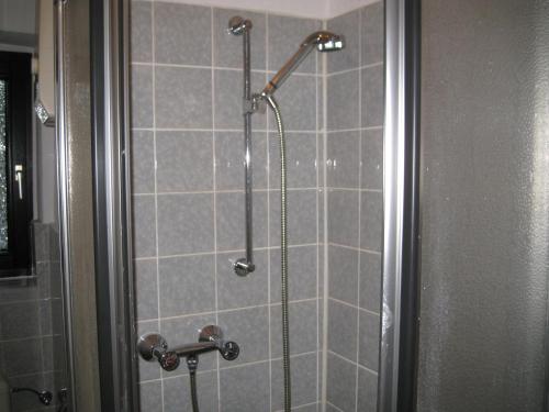 eine Dusche im Bad mit grauen Fliesen in der Unterkunft Abels Appartements in Bochum
