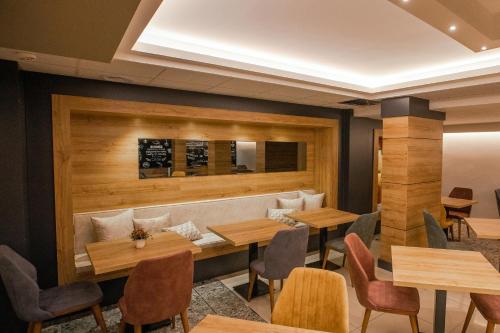 a restaurant with wooden walls and tables and chairs at Adresin Hotel in Edirne