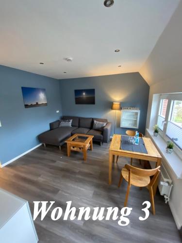 a living room with a couch and a table at Haus Waldenfels in Sankt Peter-Ording